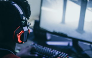 Mann spielt am PC mit Headset